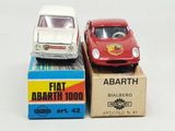 two toy cars sitting on top of a box next to each other