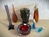 de nombreux vases en verre de différentes couleurs sur la table