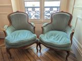 une paire de fauteuils rembourrés bleus placés devant une fenêtre