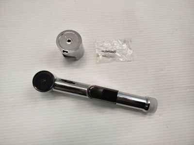 un objet noir et argenté posé sur une table, à côté d'un objet argenté