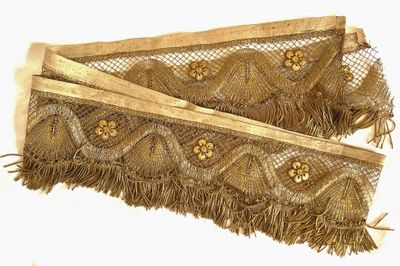 deux morceaux de tissu ornés de perles dorées et de franges