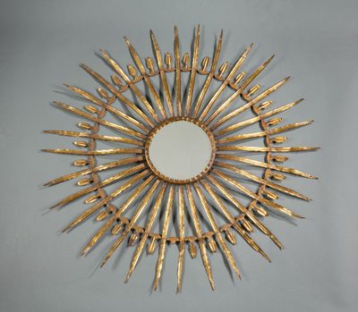 un motif en forme d'étoile dorée avec un miroir accroché au mur