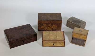 quatre petites boîtes en bois posées sur une surface blanche