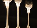 three forks and two spoons sitting on a table