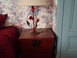 une lampe posée sur une table à côté d'un lit