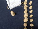 wooden chess pieces in a bag on a blue surface