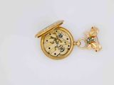a small gold pocket watch with a butterfly on it