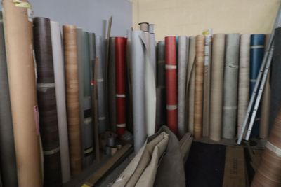 de nombreux rouleaux de tissu sur une étagère dans une pièce