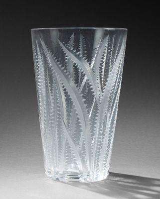 un verre transparent orné d'un motif, posé sur une table