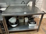 une cuisine équipée d'une table en inox et d'un micro-ondes