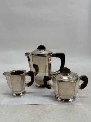 three pieces of silver tea and coffee set on a white surface