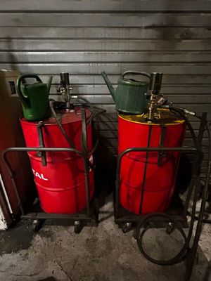 deux fûts rouges et un bidon vert posés sur un chariot