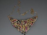 un gros plan d'un collier en or orné de pierres multicolores