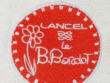 embroidered logo on a white shirt with a red circle and a flower on it