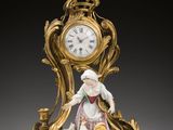 une horloge en or ornée d'une figurine représentant une femme tenant un panier
