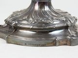 a silver candle holder with a candle on top of it