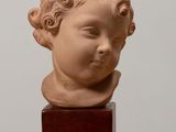 sculpture of a child ' s head on a wooden block