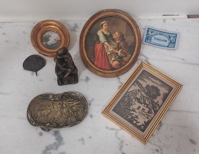 une table en marbre sur laquelle se trouvent une photo, un cadre, un tableau et d'autres objets