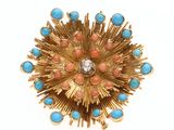une image représentant une broche en or et turquoise sur fond blanc