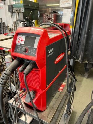 une photo d'une soudeuse rouge et noire dans un atelier