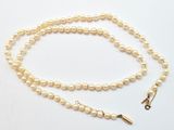 gros plan d'un collier de perles sur fond blanc