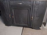a black cabinet with a door and a sign on the wall