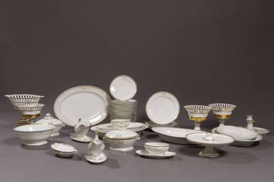 beaucoup d'assiettes et de bols blancs et dorés sur la table