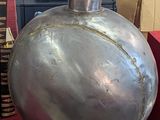 a large metal flask sitting on a table next to a stack of books