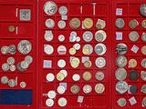 de nombreux types de pièces de monnaie dans une vitrine rouge