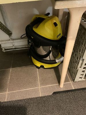 a yellow vacuum cleaner sitting under a sink in a bathroom