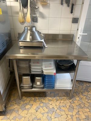a stainless steel table in a kitchen with pots and pans on it