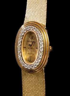an image of a close up of a gold watch with a diamond bezel