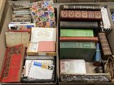 une boîte remplie de livres de toutes sortes posée par terre