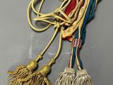 two tassels are tied together on a gray surface