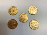 quatre types différents de pièces d'or sur une surface blanche