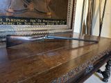 une table en bois sur laquelle est posé un pistolet