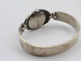 a close up of a silver ring with a watch on it