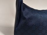 a blue guccissi bag with a black handle on a white background