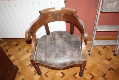 a wooden chair with a leather seat on a hard wood floor