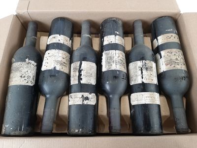 six bouteilles de vin se trouvent dans une boîte en carton posée sur une surface blanche