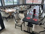 tables and chairs in a restaurant with a view of the city
