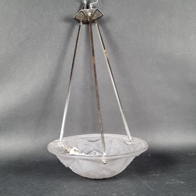 une image représentant un bol en verre suspendu à un crochet métallique sur fond gris