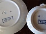 a white plate with a blue stamp on it next to a white plate with a blue stamp on it