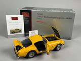 the yellow model car is next to a boxed box of books