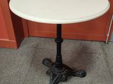 a white marble top table with a black iron base