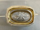 silver and gold ring with a clear glass center on a white surface