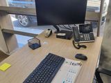 un bureau sur lequel se trouvent un clavier, un téléphone et un écran
