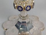 a silver chalicet on a stand with coins around it