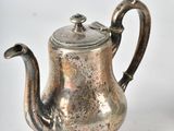 a silver tea pot and a silver tea pot on a table