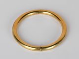 gros plan d'une bague en or sur une surface blanche